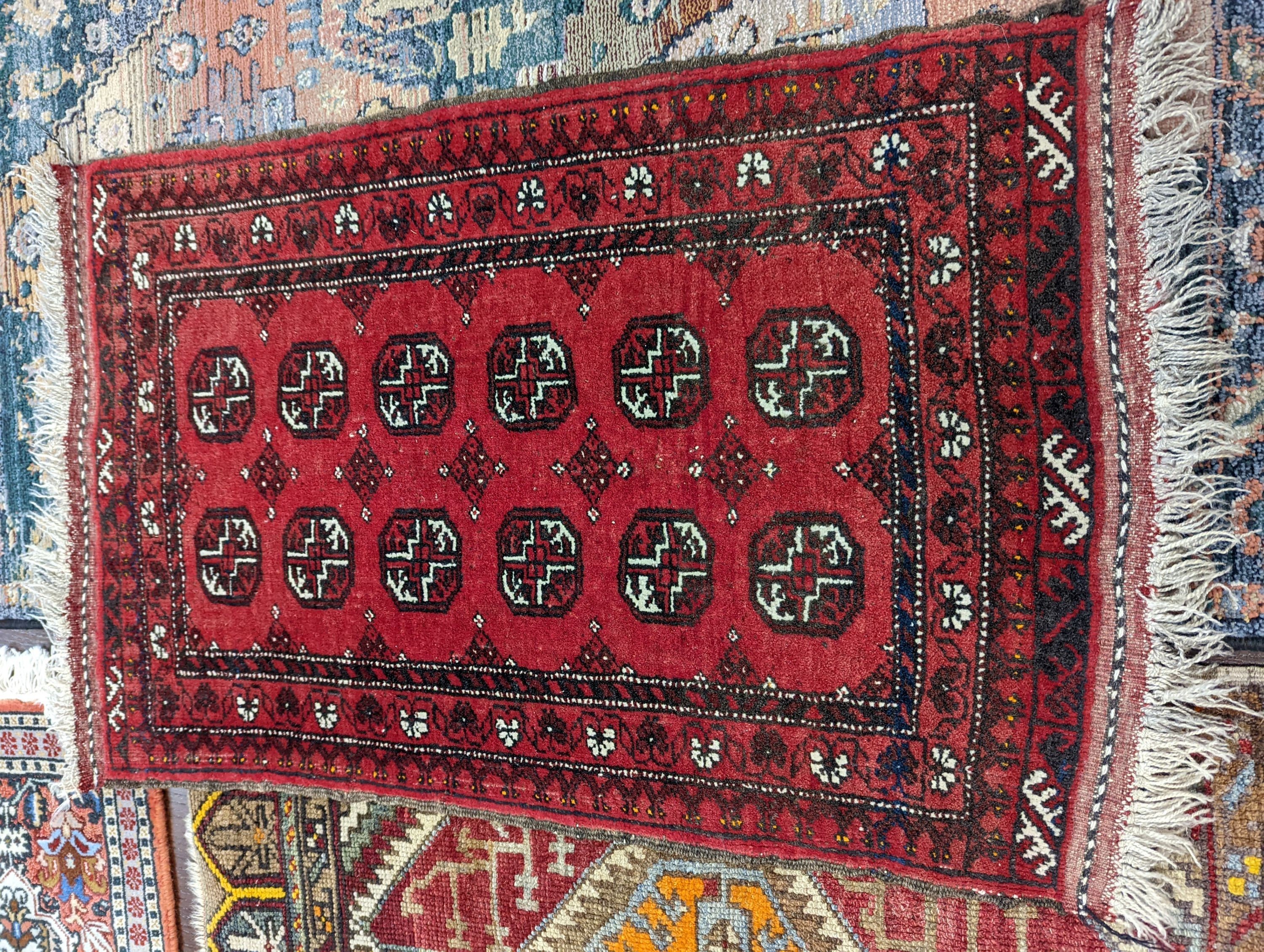 A Caucasian red ground mat, a Bokhara mat, three others and a blue ground rug, largest 136 x 80cm (6)